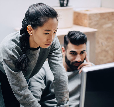Status of digital transformation in the public sector in Europe Young, Asian IT employee with pigtail shows two colleagues how they can better digitalize their processe