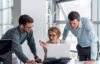 Digital transformation in the public sector begins with an IT network from LANCOM Group of three administrative employees sits in office at laptop and consults with each other